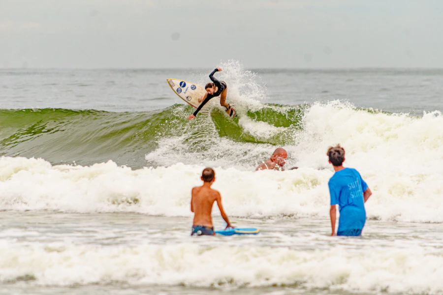 Ana Aguiar executando manobra de surf em onda