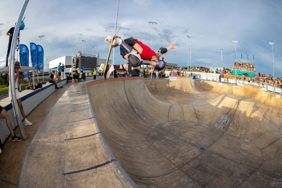 Ana Aguiar voando sobre o bowl em manobra de skate vertical