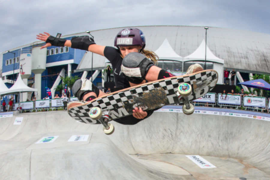 Ana Aguiar realizando manobra de skate no ar em pista bowl